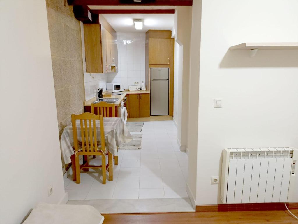 eine Küche und ein Esszimmer mit einem Tisch und Stühlen in der Unterkunft Sentir Galicia Apartamentos in Redondela