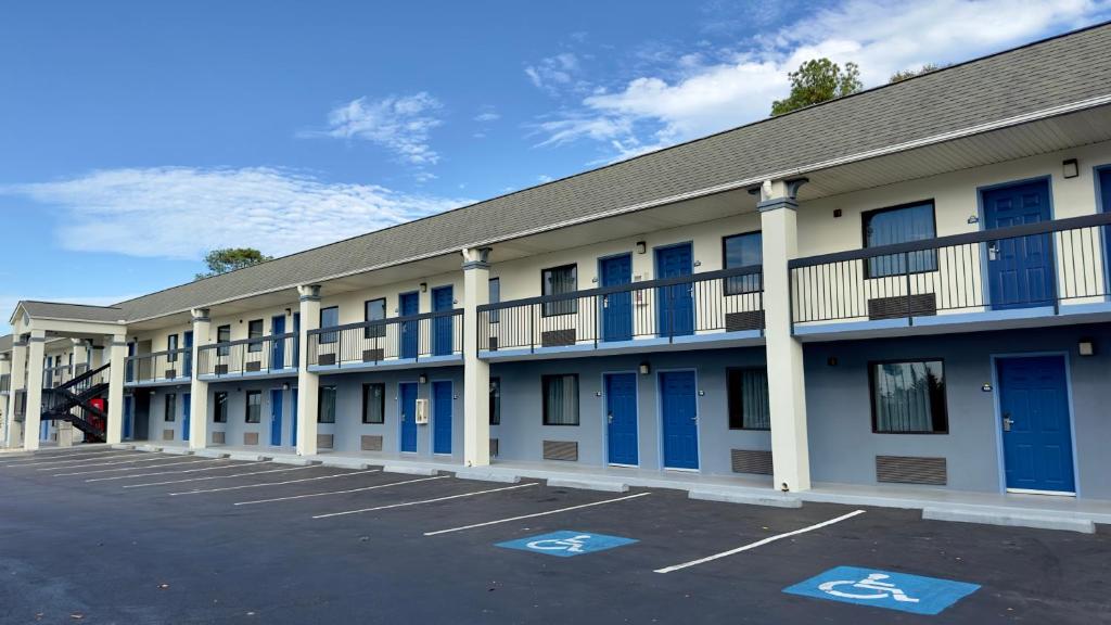 un edificio con puertas azules y aparcamiento en Days Inn By Wyndham Lexington-Columbia en Lexington