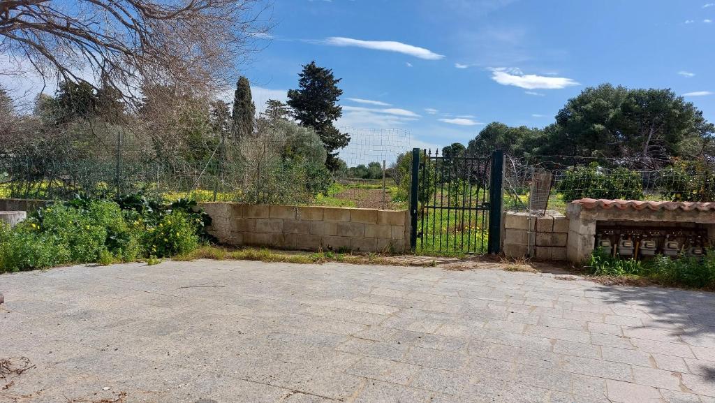 um portão num jardim com uma cerca de pedra em Appartamento 'il cortiletto' em Porto Ottiolu