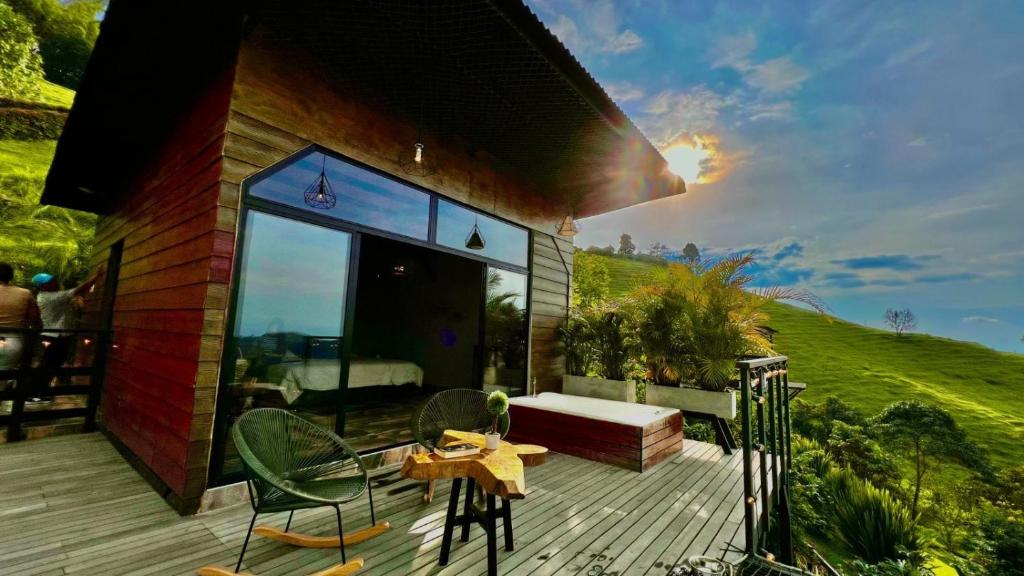 Casa con terraza con mesa y sillas en Ecovillage glamping Idilio, en Llanitos