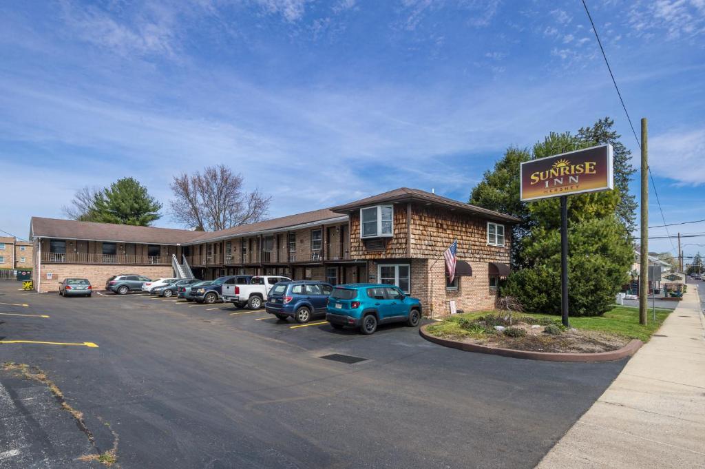 een hotel met auto's geparkeerd op een parkeerplaats bij Sunrise Inn Hershey in Hershey