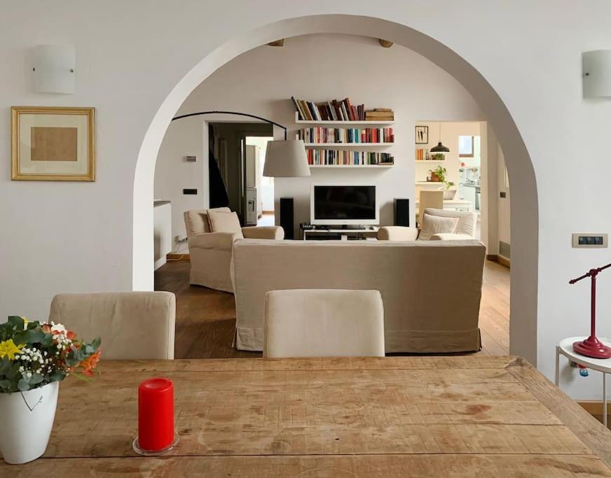 a living room with an archway with a table and chairs at Your place in San Frediano in Florence