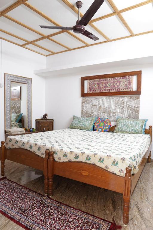 a bed in a bedroom with a ceiling fan at Prag View Heritage Homestay in Bhuj