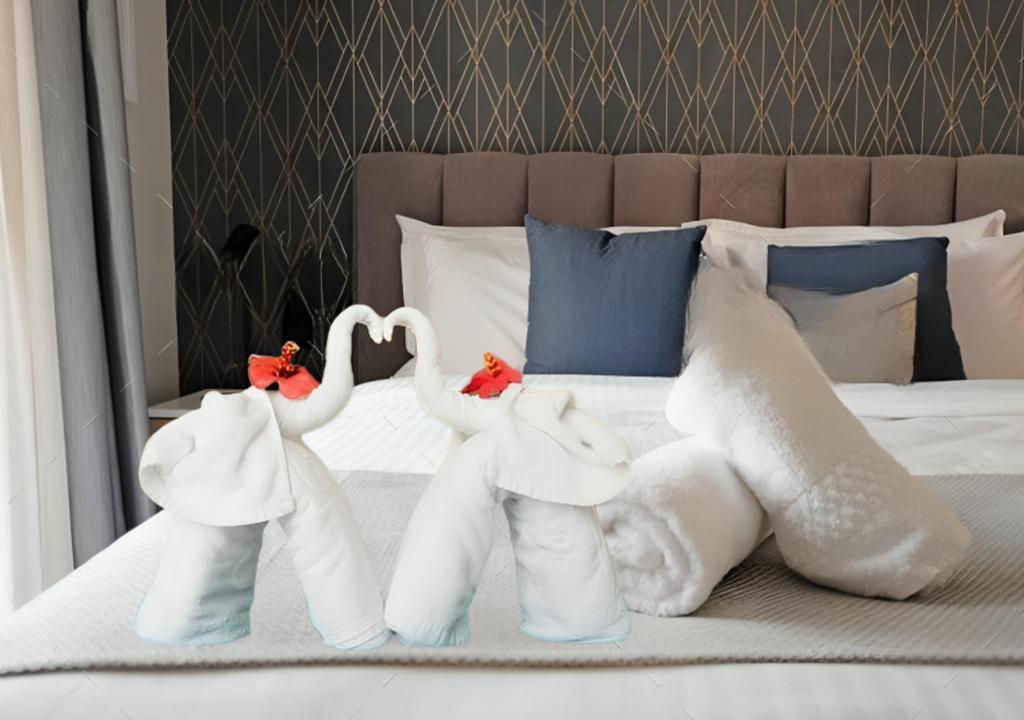 Dos toallitas animadas para parecer cisnes en una cama en Hotel Aaradhya, en Udaipur
