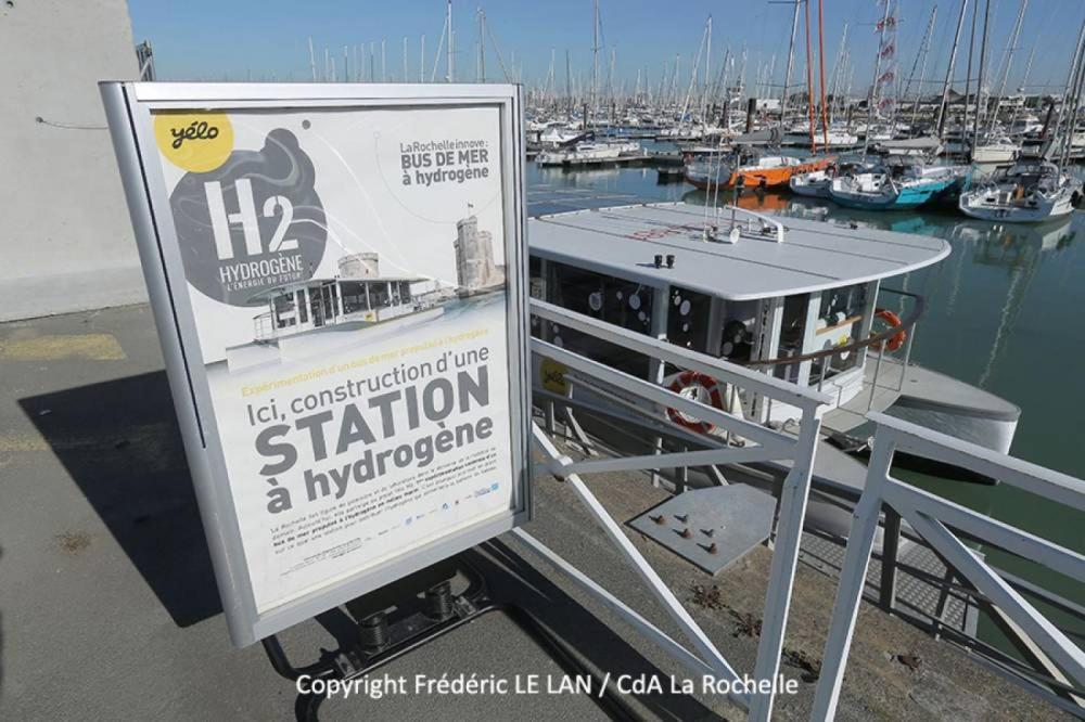 a sign on a dock with a boat in a marina at Nuit insolite dans un petit voilier in La Rochelle