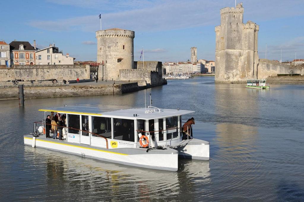 a boat in the water in front of a castle at Nuit insolite dans un petit voilier in La Rochelle