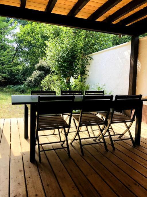 une table et des chaises sur une terrasse en bois dans l'établissement Maison familiale - Marina de Talaris - Lac Lacanau, à Lacanau