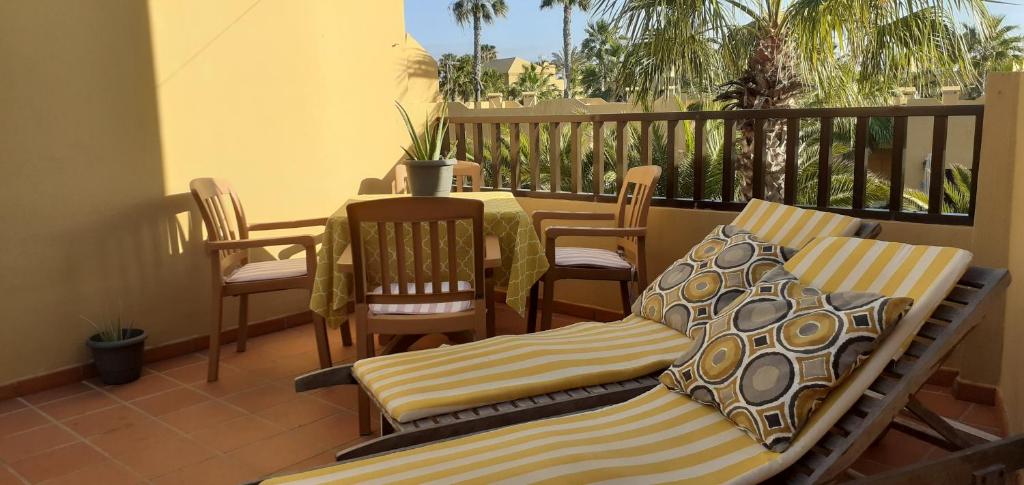 patio con mesa y sillas en el balcón en Oasis Waves House Papagayo, en Corralejo