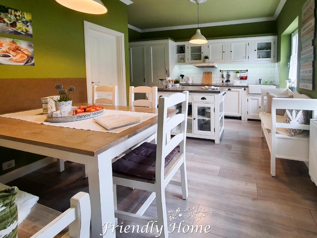 eine Küche mit einem Tisch und eine Küche mit grünen Wänden in der Unterkunft Friendly Home - Stadthaus in Bornheim