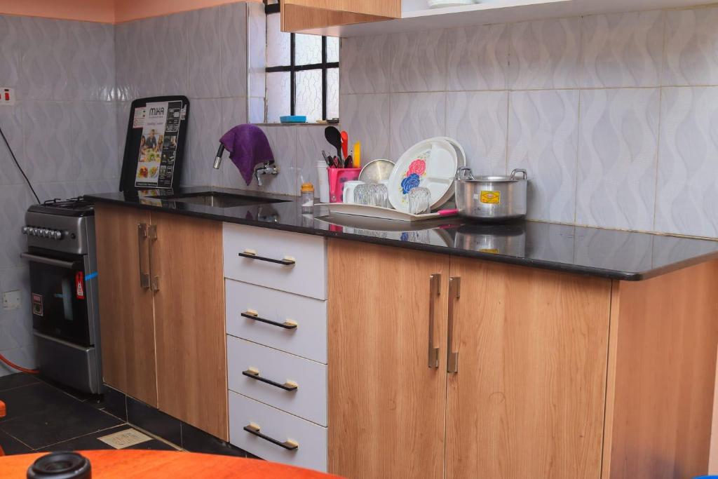 eine Küche mit einer schwarzen Arbeitsplatte und einem Herd in der Unterkunft Tamwe ltd Airbnb &studios in Meru