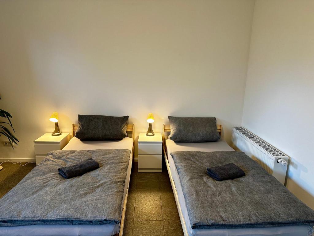 two beds in a room with two lamps on the sides at Ferienapartment am Glück in Bad Zwischenahn