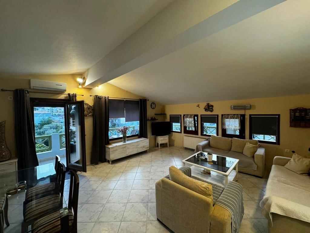 a large living room with couches and a tv at Moonbeam Townhouse Skiathos in Skiathos