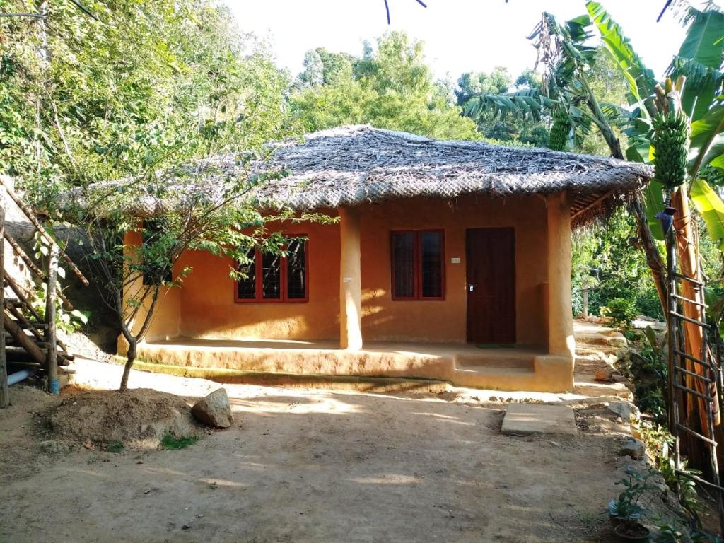 een klein huis met een rieten dak bij Cosmic Mud House Kanthalloor in Kanthalloor