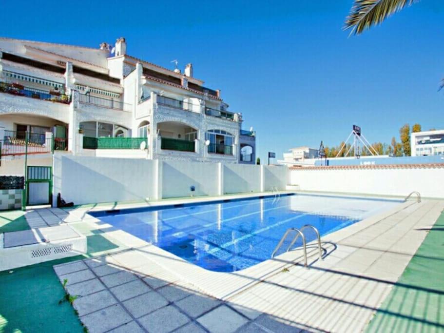 a house with a swimming pool in front of a building at Apartamento El Hammam in Empuriabrava