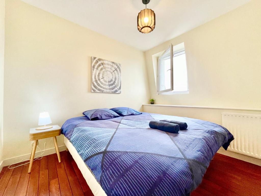 a bedroom with a bed with a blue comforter at Brest Centre - Appartements - Le Vauban - Lumineux - Centre Ville - Proche Boutiques et Restaurants in Brest