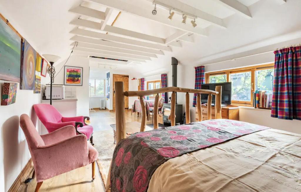 a bedroom with a bed and chairs in a room at The Barn @ Box Farm in Middlezoy