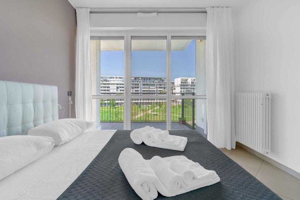 ein Schlafzimmer mit zwei weißen Hausschuhen auf einem Teppich in der Unterkunft Santa Giulia Suite - Futurismo 17 in Mailand