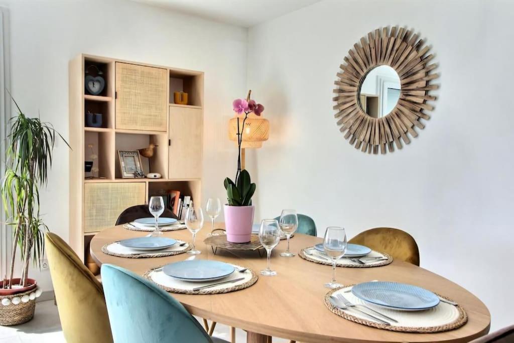 - une table à manger avec des chaises et un miroir dans l'établissement Maison bord de mer avec Jacuzzi, à Penmarcʼh