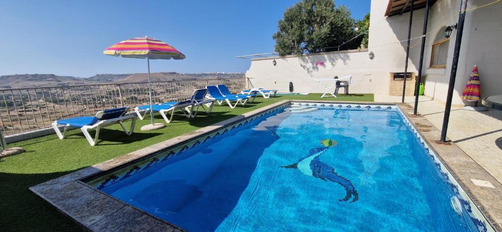 a swimming pool with a mermaid painted on it at Modern Home - Valley view Pool in Xagħra