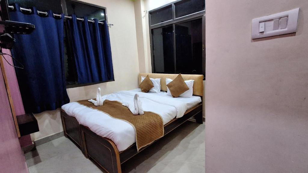 um quarto com uma cama com lençóis brancos e almofadas em Shree Balaji Paying Guest House em Varanasi