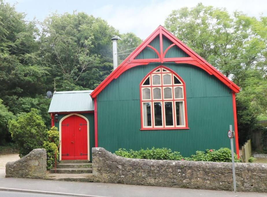 a green and red building with a red door at Tin tabernacle perfect for group getaways in Chale