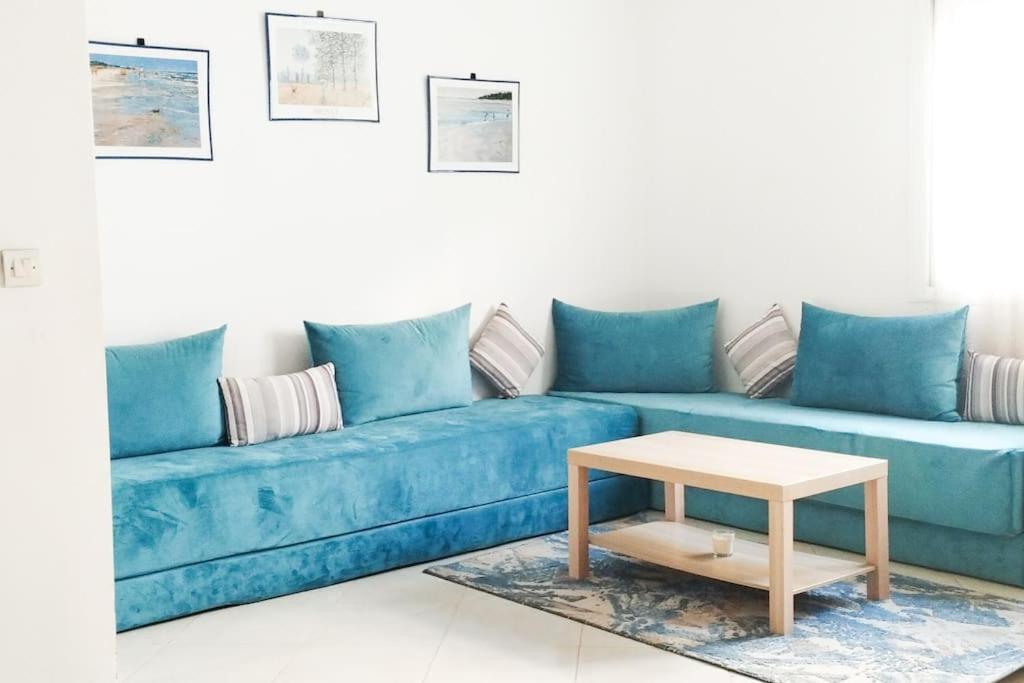 um sofá azul com uma mesa de centro numa sala de estar em Calme Cozy appartement/Tamaris em Casablanca