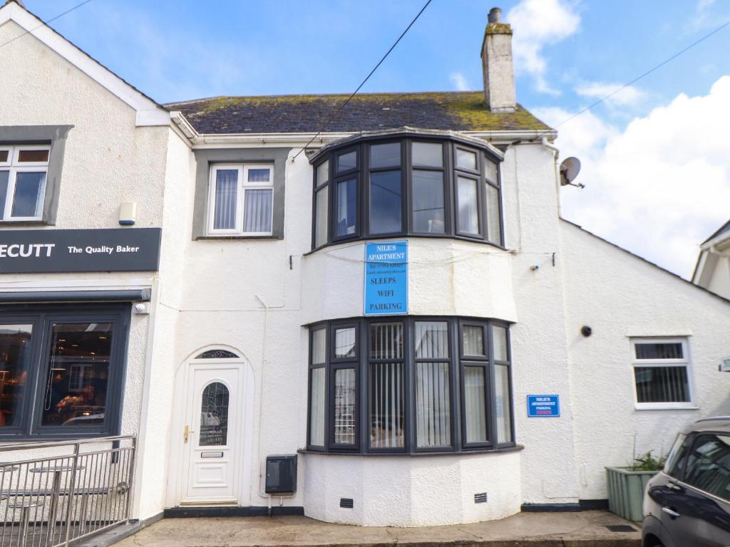 an older white house with black windows at Flat 1 Niles Place in Padstow