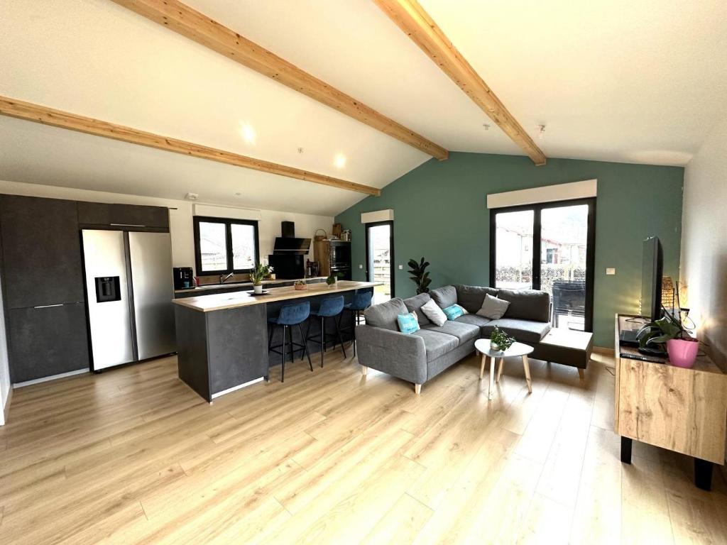 a large living room with a couch and a kitchen at Le cap in Lit-et-Mixe
