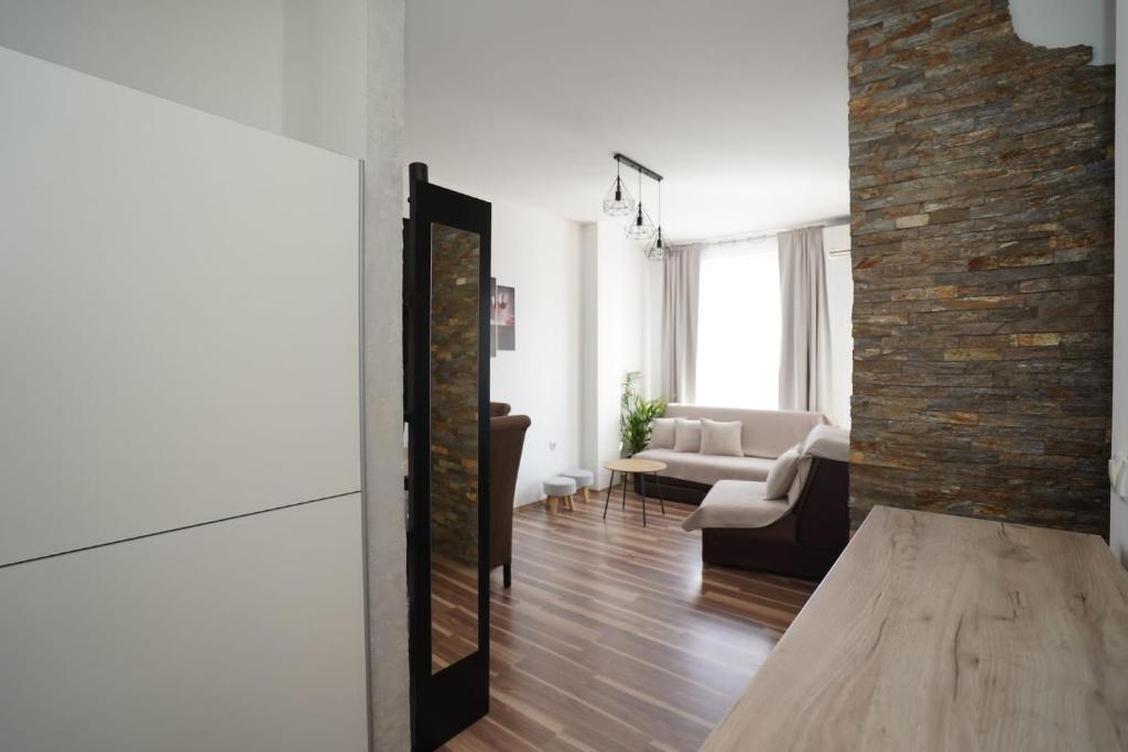 a living room with a couch and a brick wall at Todor Apartmani in Kladovo
