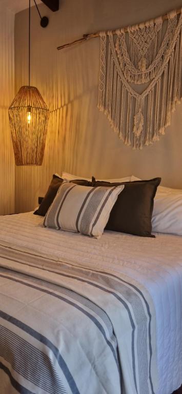 - une chambre avec un grand lit blanc et des oreillers dans l'établissement Terrambú, à La Paisanita