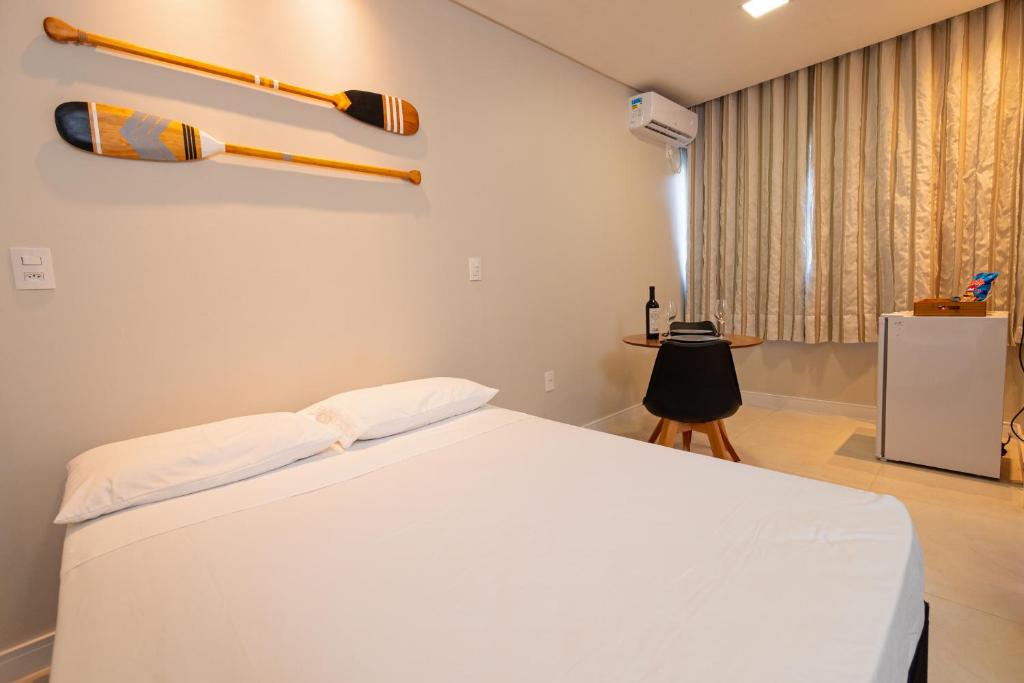 - une chambre avec un lit et une batte de baseball sur le mur dans l'établissement Pousada Kauai SFS, à São Francisco do Sul