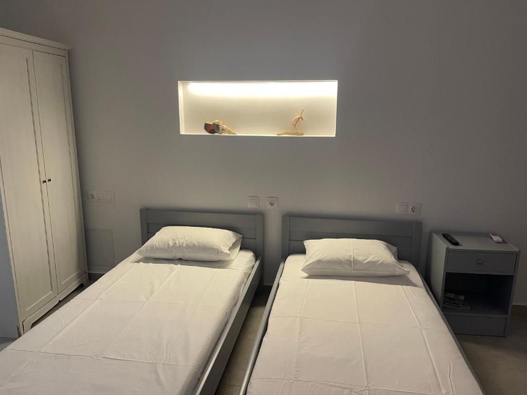 2 camas en una habitación pequeña con una foto en la pared en Tourlos House en Andiparos