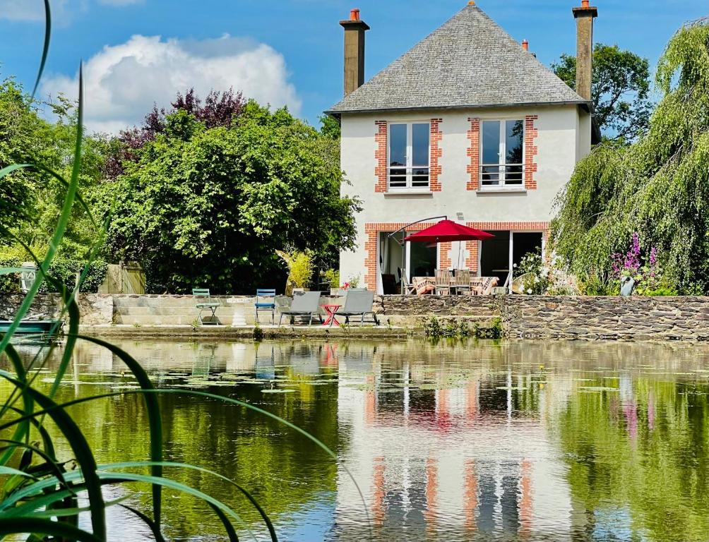 una casa seduta sopra un corpo d'acqua di Le Moulin de Bury, Maison de campagne au bord de la rivière à 13 kms au Sud de Rennes a Chavagne