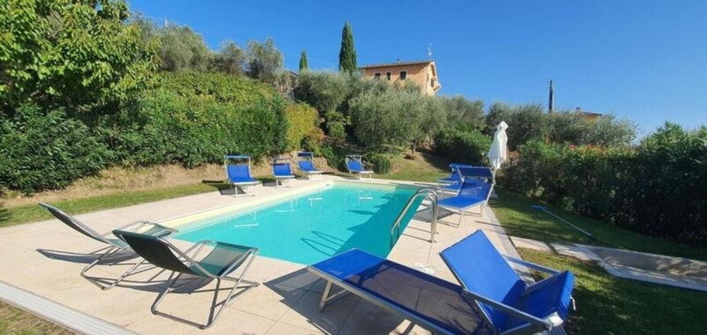 eine Gruppe Stühle und ein Pool in der Unterkunft Ferienhaus für 16 Personen in Capannori, Toskana Provinz Lucca in Valgiano
