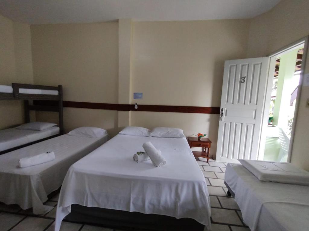 ein Schlafzimmer mit 2 Betten und Handtüchern darauf in der Unterkunft Pousada Arco Iris Ilhéus in Ilhéus