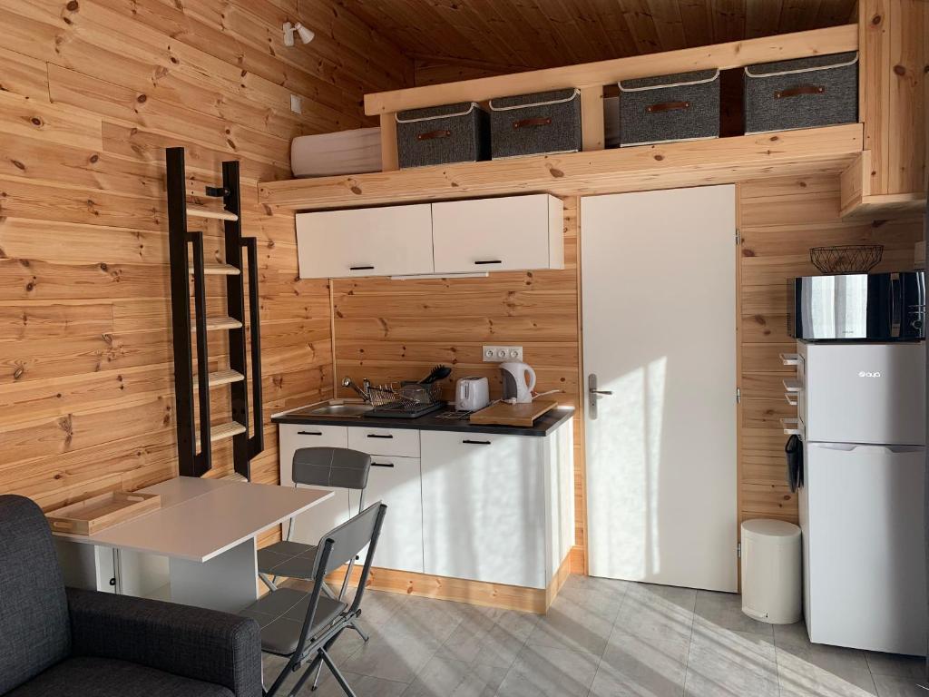 a small kitchen with a table and a refrigerator at Eco-Lodge de Cëuse in Sigoyer