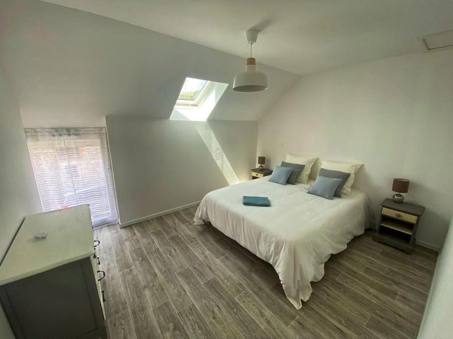 ein Schlafzimmer mit einem weißen Bett und einem Fenster in der Unterkunft Le Catalpa, gite avec piscine et jacuzi privés in Lestiou