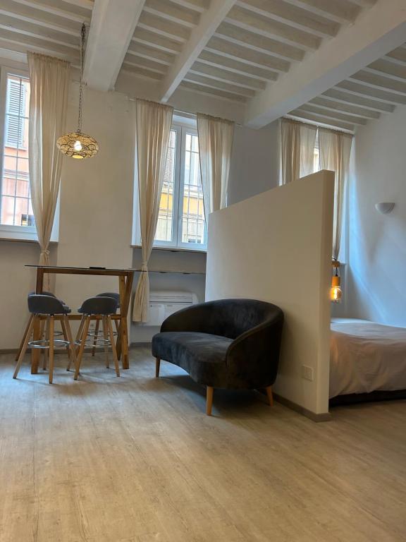 een slaapkamer met een bed, een stoel en een tafel bij Splendido Loft Centro Storico Parma in Parma