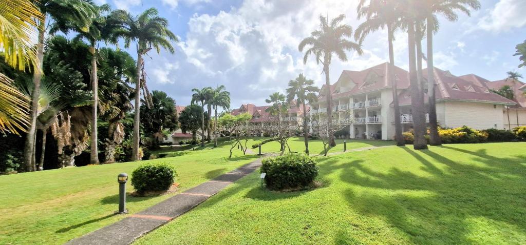 a house with palm trees in front of a yard at Studio &quot;Prestige&quot; Sainte Luce in Sainte-Luce