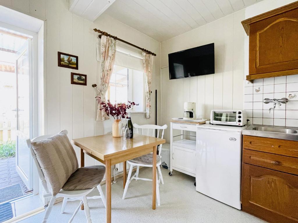 cocina con mesa de madera y mesa pequeña con sillas en Ferienwohnung ‘Storchennest’, en Tauche