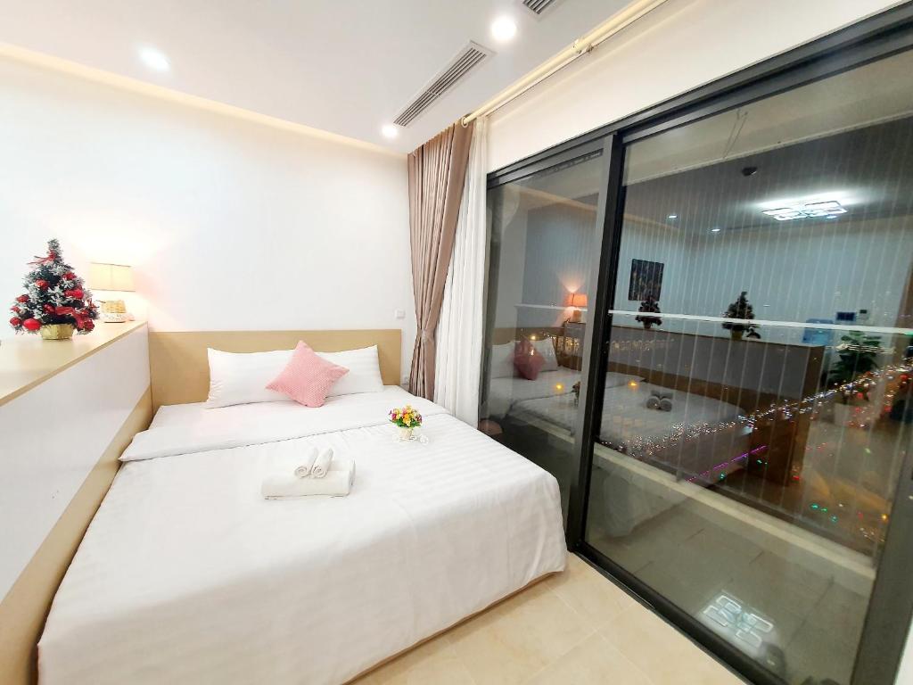 - une chambre avec un lit blanc et un arbre de Noël dans l'établissement Studio Luxury Apt D'Capitale #Jerry's House, à Hanoï