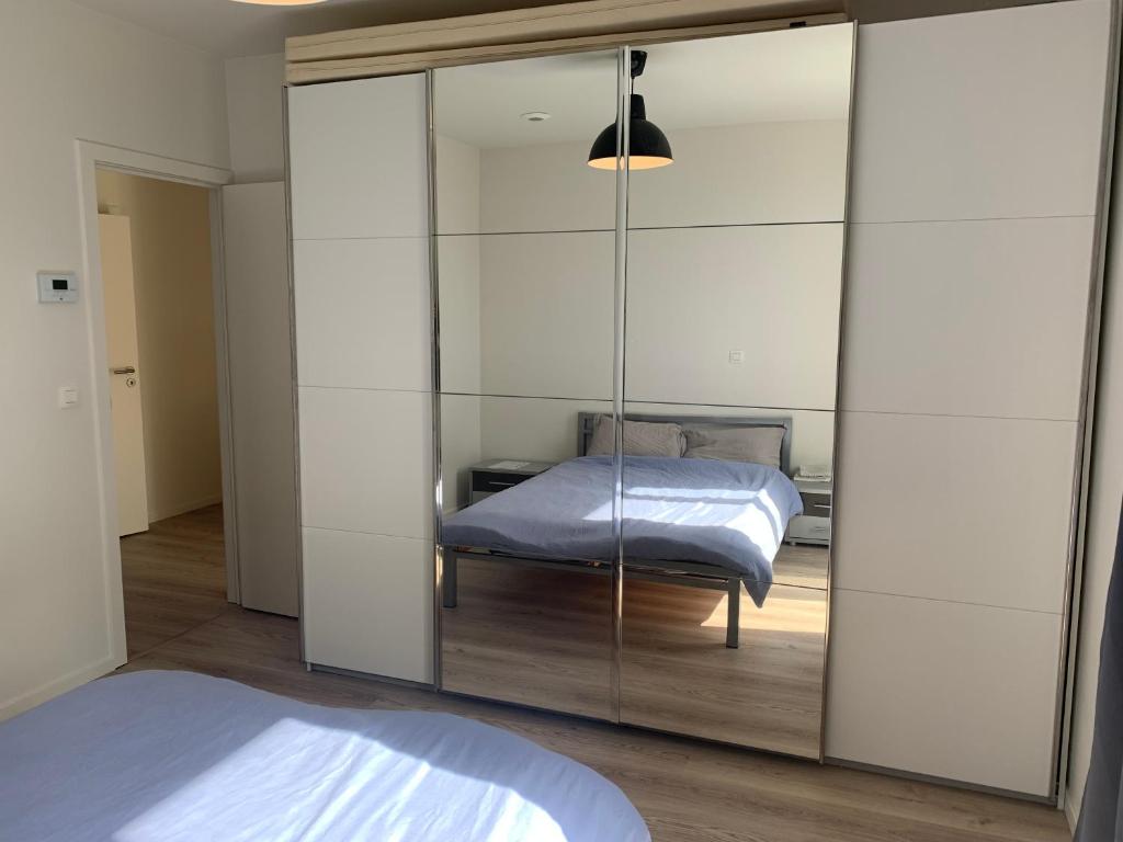 a bedroom with a mirrored closet with a bed in it at Private Room in Shared House in Ostend