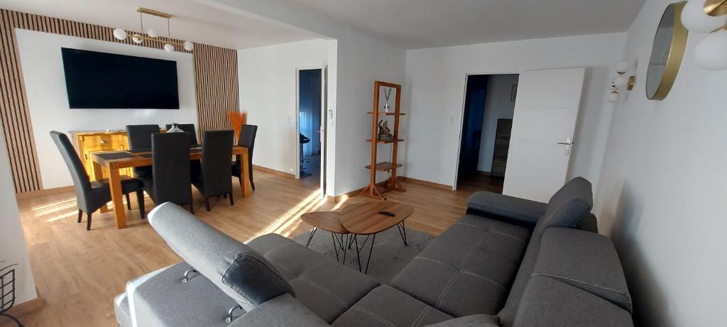 un salon avec un canapé et une salle à manger dans l'établissement Nouvel Appartement à 10mn à pied du Centre-Ville, à Albi