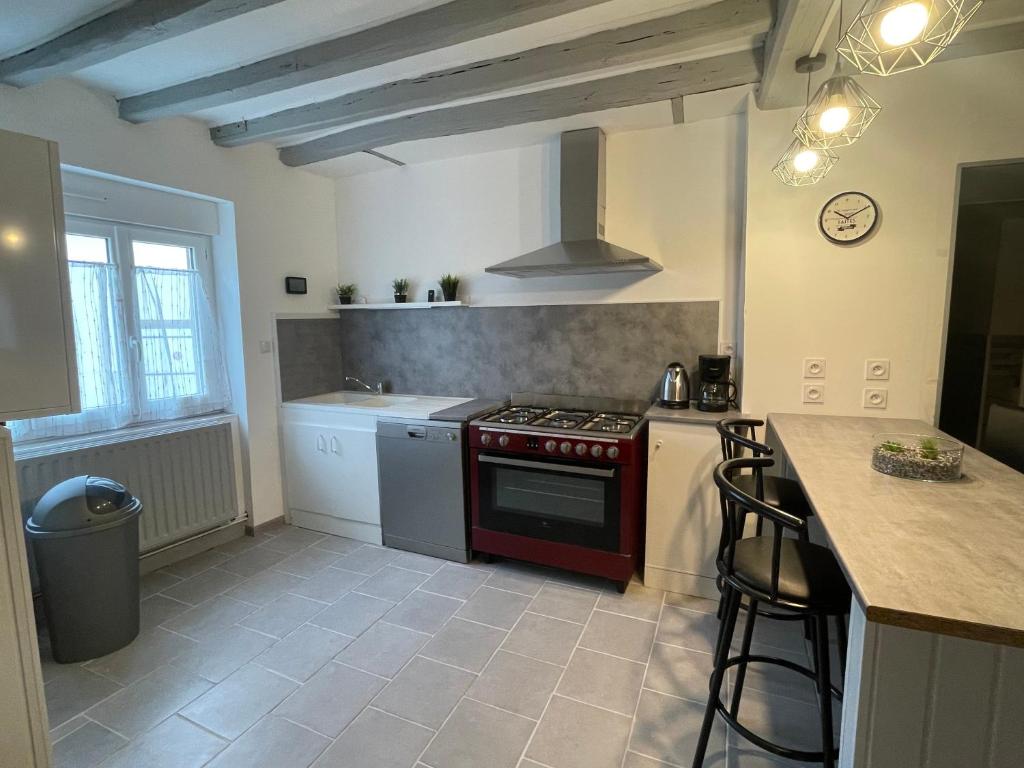 Il comprend une cuisine équipée d'une cuisinière rouge et d'un comptoir. dans l'établissement Gîte o prés de la Loire, à Ousson-sur-Loire