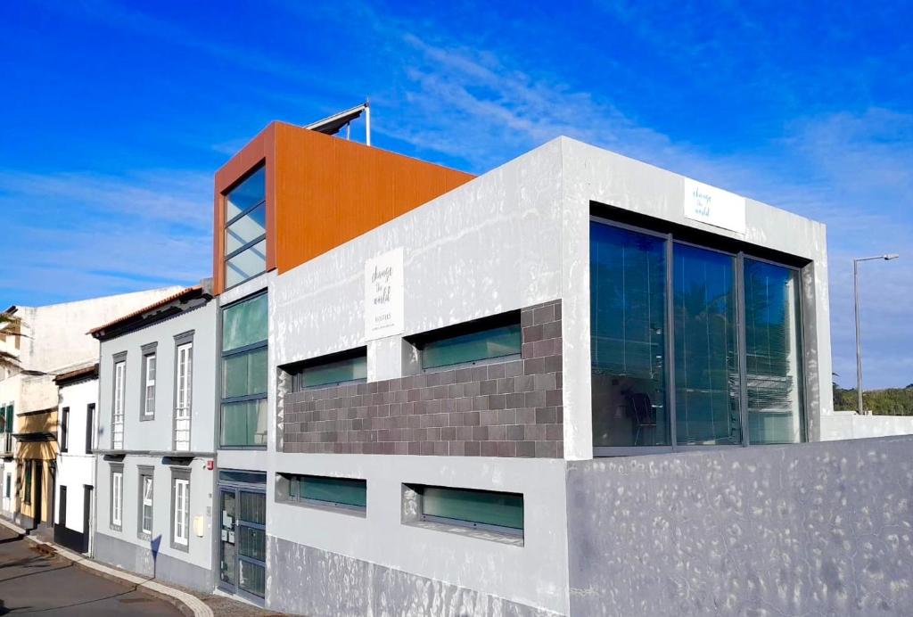 un bâtiment orange et blanc dans une rue dans l'établissement Change The World Hostels - Açores - Ponta Delgada, à Ponta Delgada