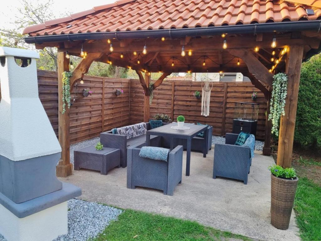 a wooden pergola with a table and chairs under it at Apartament MASHOUSE Stegna in Stegna