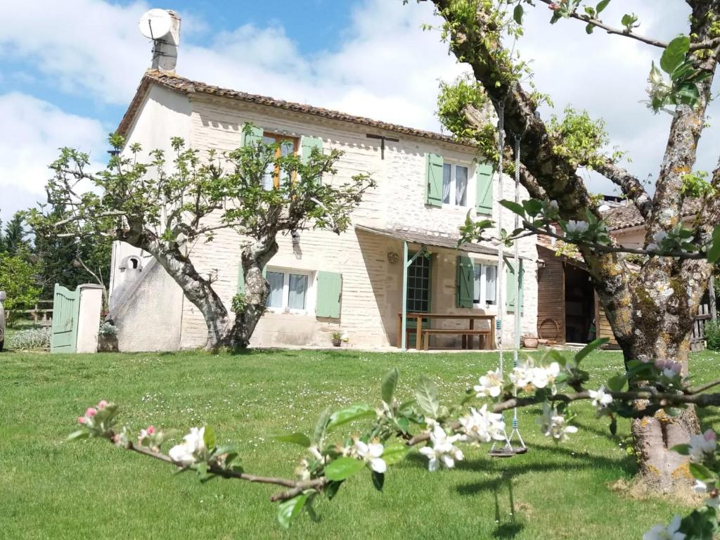 uma casa branca com árvores no quintal em Gîte des Gravets em Sigalens