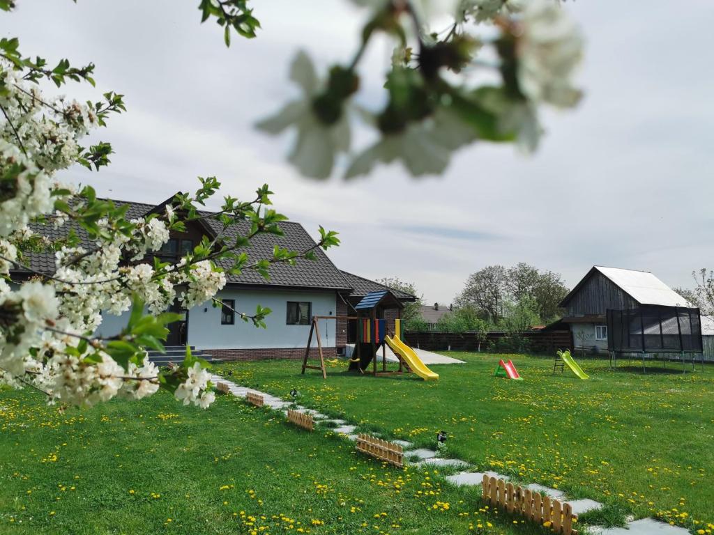 un patio con parque infantil y una casa en Vila Lazar, en Cut