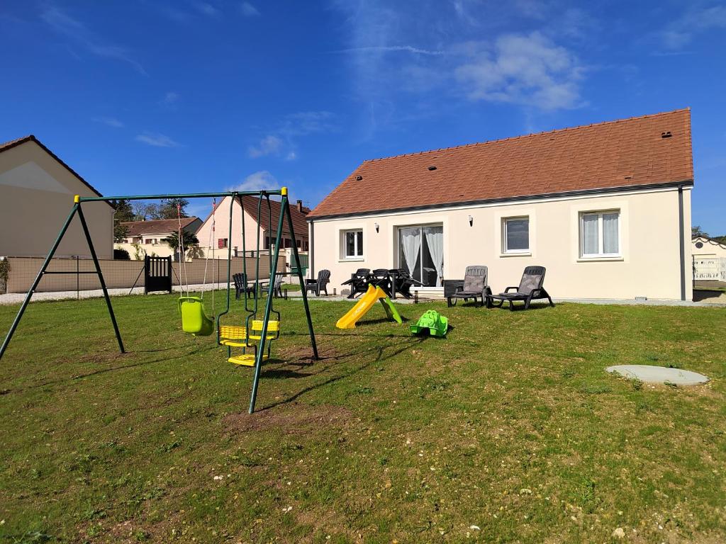 une cour avec une aire de jeux et une maison dans l'établissement Maison à la campagne, à Villiers-sur-Tholon