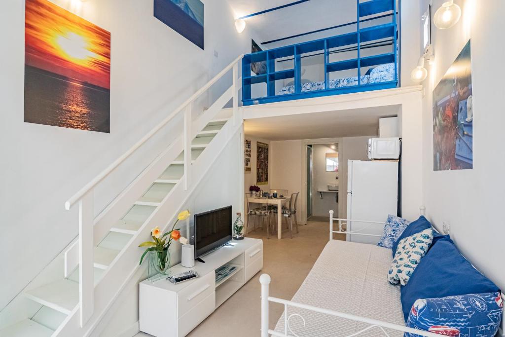 uma sala de estar com uma cama alta e uma escada em La Spiaggetta em Porto Azzurro